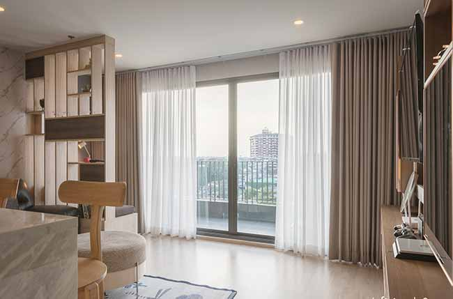 Căn hộ 50m2 thiết kế mở với cửa kính lớn và rèm mỏng, giúp lưu thông không khí và đón sáng tự nhiên hiệu quả